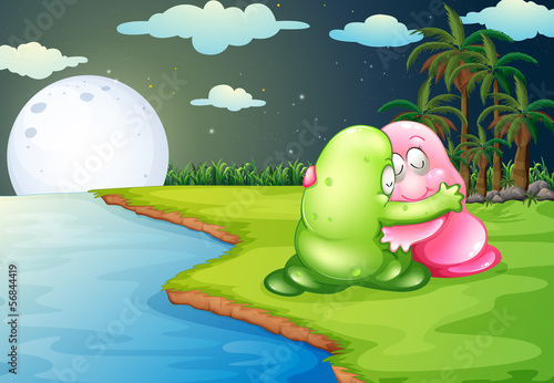 A green monster comforting the pink monster at the riverbank