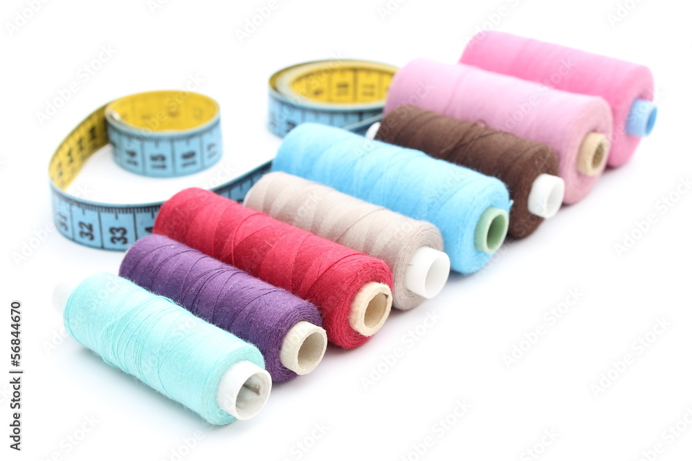 Colorful spools of thread tape measure on white background Colorful spools of thread tape measure on white background