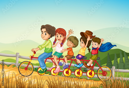 Happy kids riding the bicycle at the farm