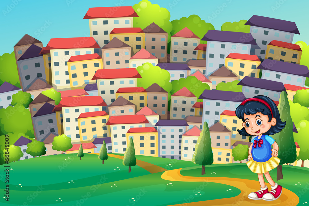 A young girl walking at the hilltop across the tall buildings