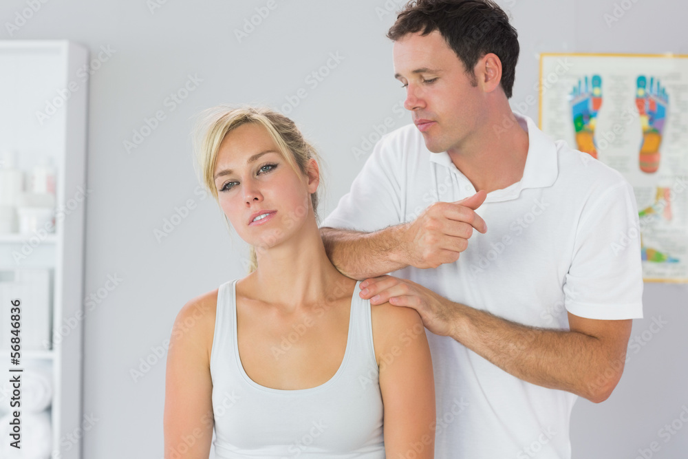 Fototapeta premium Attractive physiotherapist massaging patients neck with elbow
