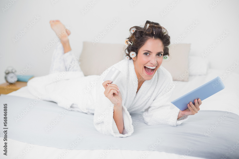 Laughing natural brunette using tablet and credit card Laughing natural brunette using tablet and credit card