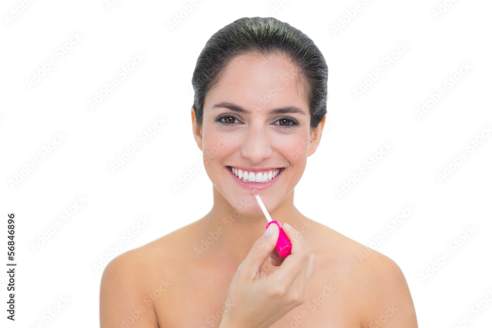 Smiling bare brunette applying lip gloss Smiling bare brunette applying lip gloss