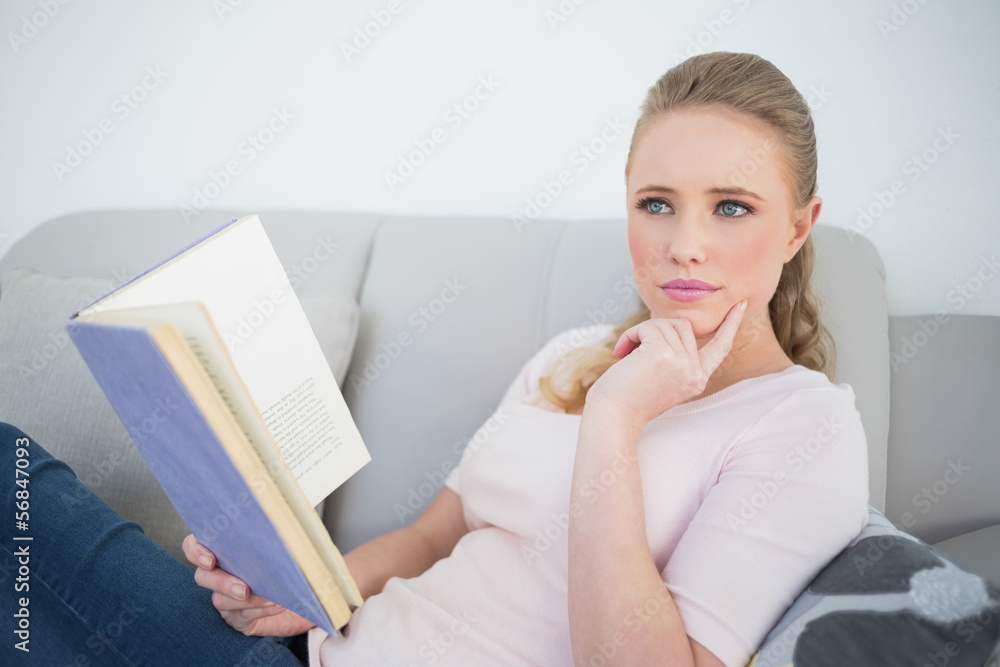 Casual thoughtful blonde holding a book Casual thoughtful blonde holding a book