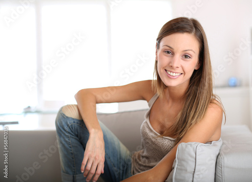 Beautiful young woman sitting in couch at home