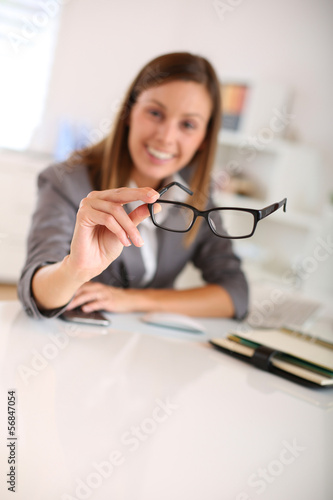 Closeup of eyeglasses held by businesswoman