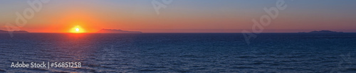 Panoramic shot of beautiful coastal sunset with some islands on