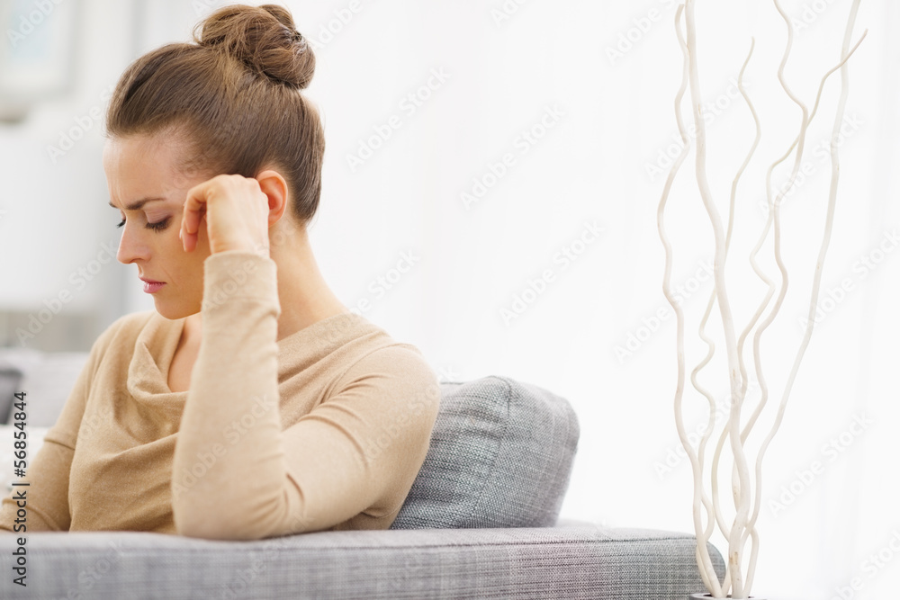 Frustrated young housewife sitting on couch Frustrated young housewife sitting on couch