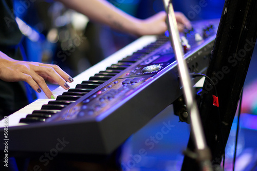 hands of musician playing keyboard in concert