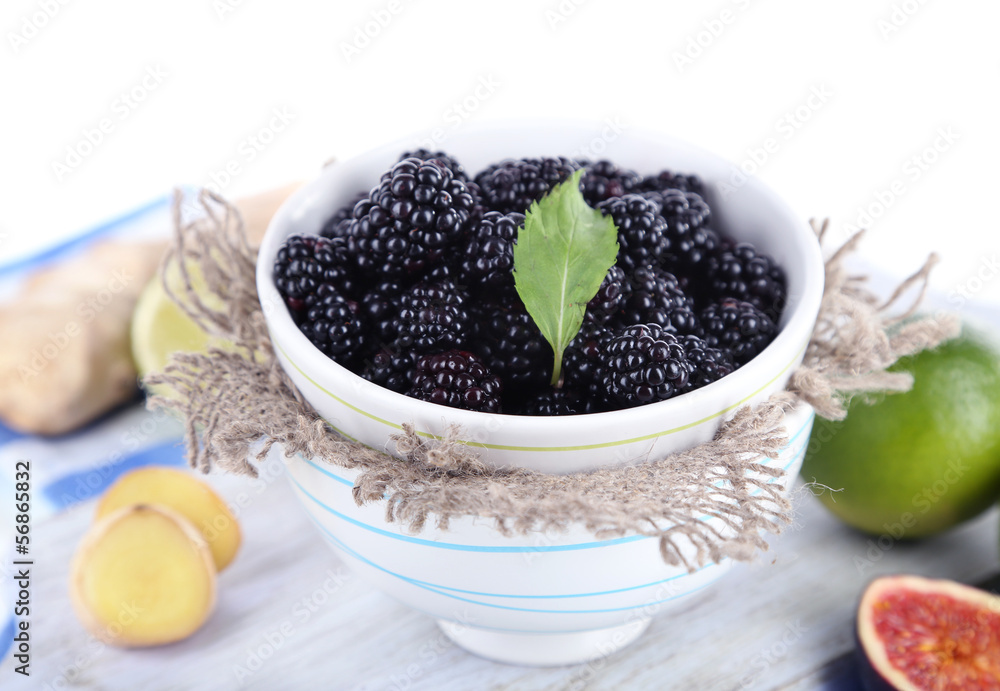 Blackberry in small bowl on board on napkin isolated on white Blackberry in small bowl on board on napkin isolated on white
