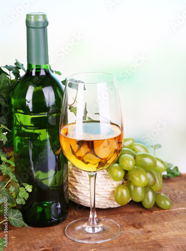 Ripe green and purple grapes in basket with wine