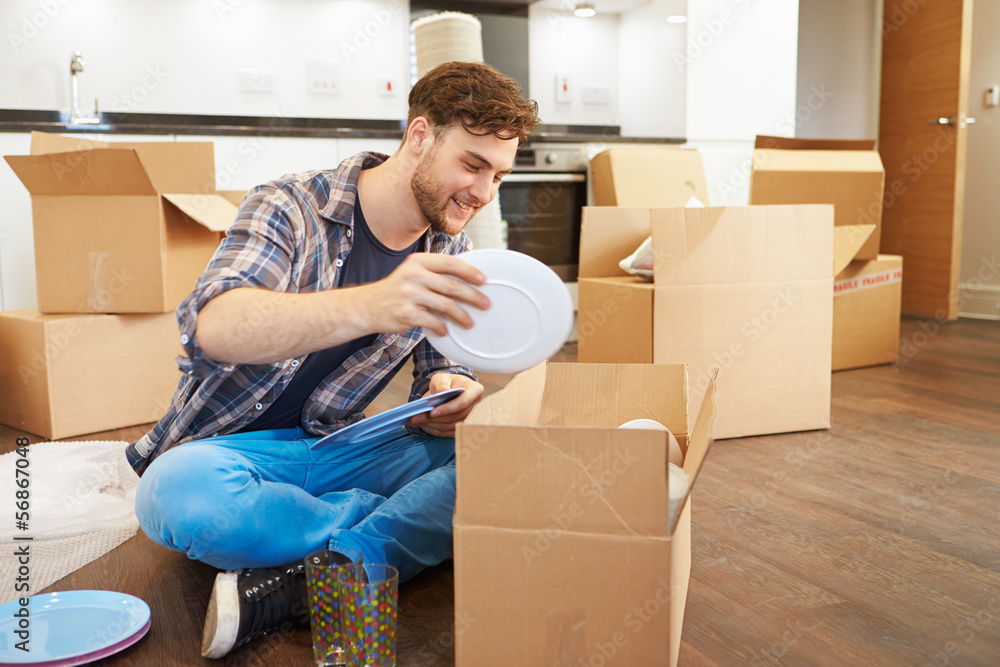 Man Moving Into New Home And Unpacking Boxes Man Moving Into New Home And Unpacking Boxes
