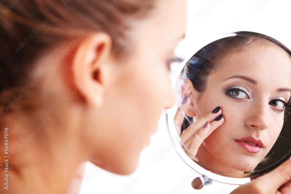 Beautiful girl preens before small mirror isolated on white Beautiful girl preens before small mirror isolated on white
