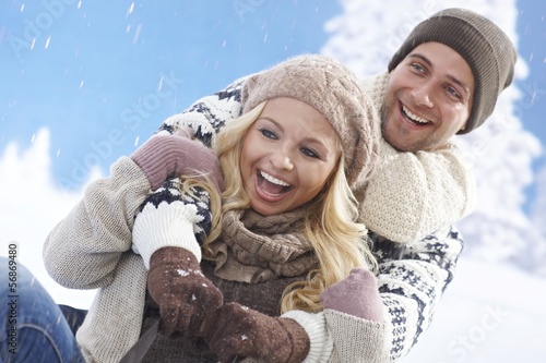 Obraz na plátně Happy loving couple sledging
