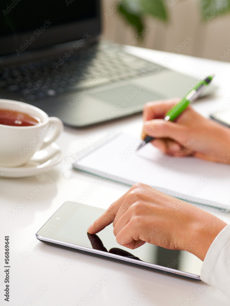 Woman hands with tablet PC and notepad at office Woman hands with tablet PC and notepad at office