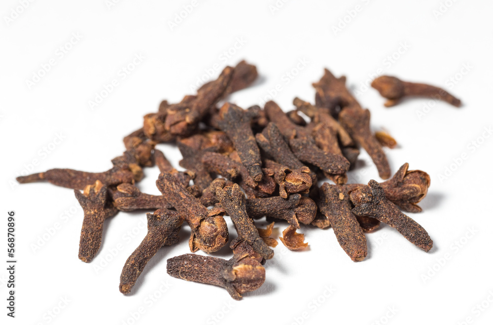 Dry cloves on white background. Selective focus. Dry cloves on white background. Selective focus.