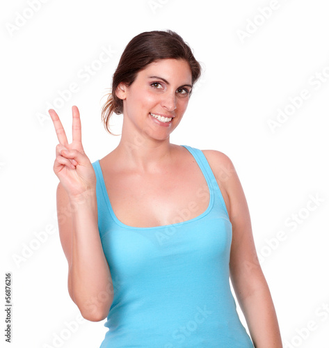 Young woman in gym clothing gesturing victory sign