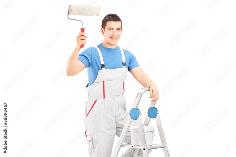 Male painter holding a roller and standing on a ladder Male painter holding a roller and standing on a ladder
