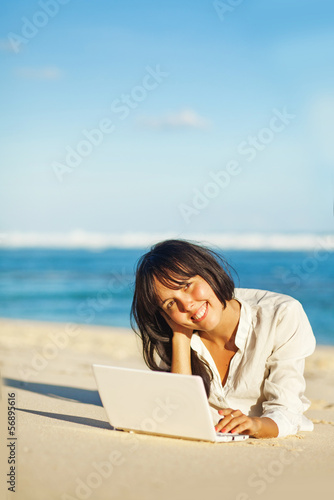 woman with laptop on a beach 
