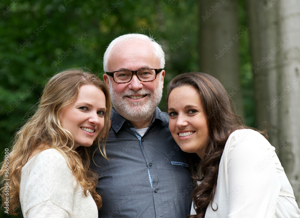 Fototapeta premium Happy father together with two smiling daughters