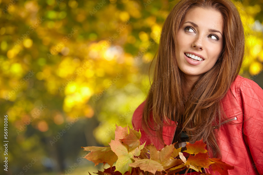 Beautiful elegant woman standing in a park in autumn Beautiful elegant woman standing in a park in autumn