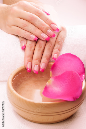pink manicure with fragrant rose petals and towel. Spa