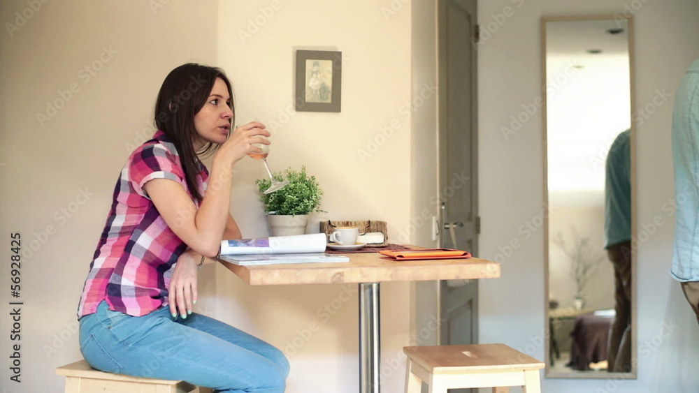 Couple at home, husband pouring wine to his wife reading magazin Couple at home, husband pouring wine to his wife reading magazin
