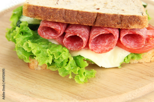 Tasty sandwich with salami sausage and vegetables