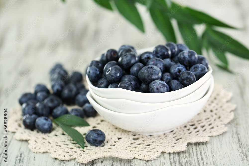 Blueberries in plates on napkin on wooden background Blueberries in plates on napkin on wooden background