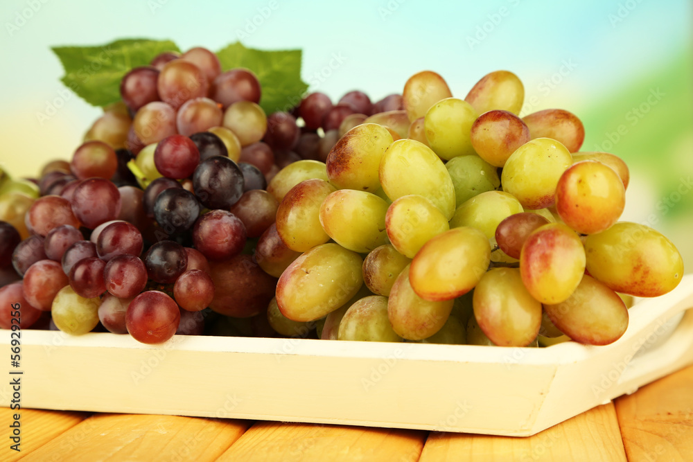 Fresh grape on wooden tray on bright background Fresh grape on wooden tray on bright background