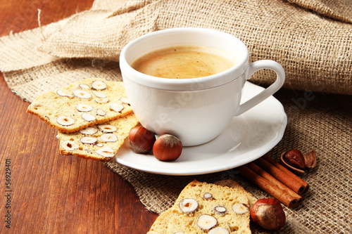 Cup of tasty coffee with Italian biscuit, on wooden background