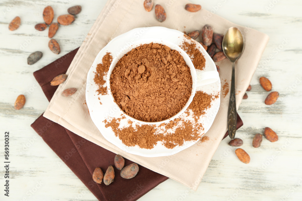 Cocoa powder in cup on napkin on wooden table Cocoa powder in cup on napkin on wooden table