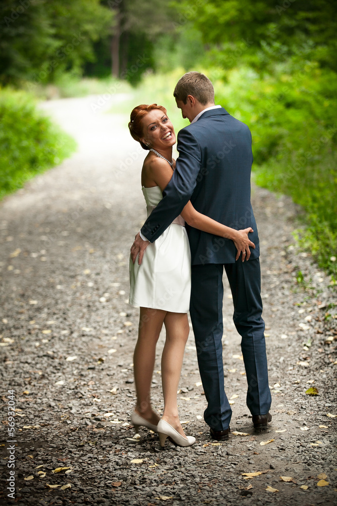 Obraz premium Newly married couple walking in park and laughing