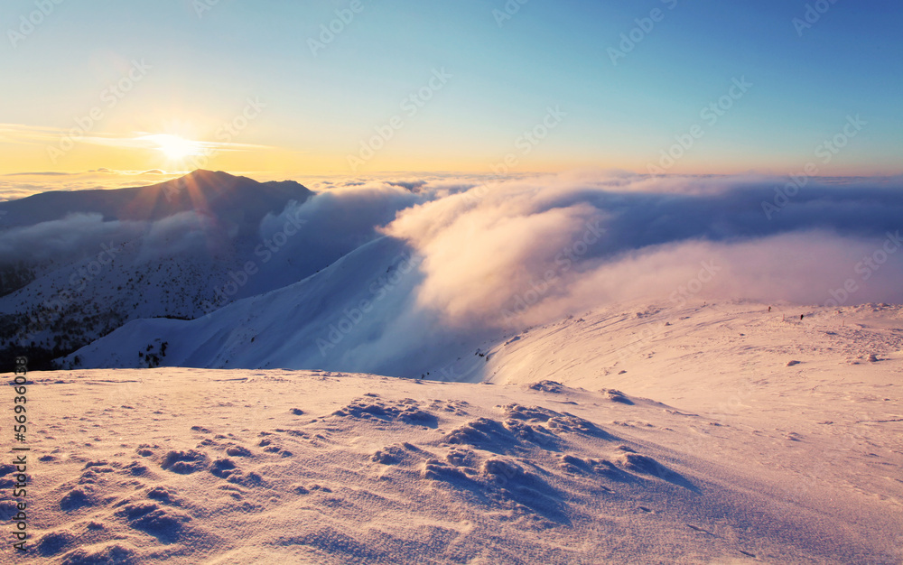 Winter sunset over the clouds with sun.