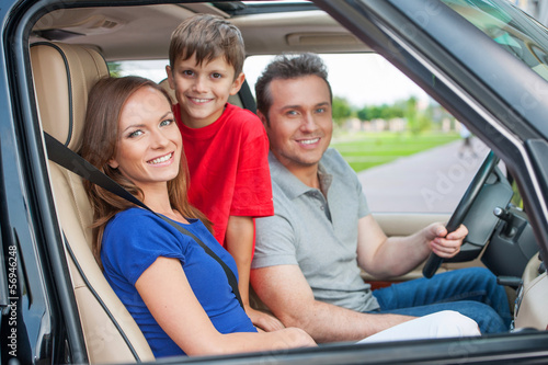 Family with one kid is travelling by car, smiling and looking at © BlueSkyImages
