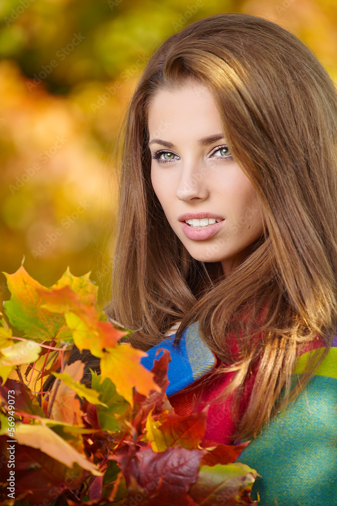 Beautiful elegant woman standing in a park in autumn Beautiful elegant woman standing in a park in autumn