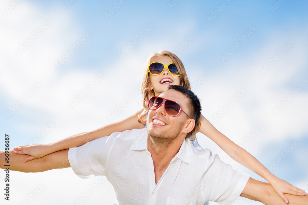 happy father and child in sunglasses over blue sky