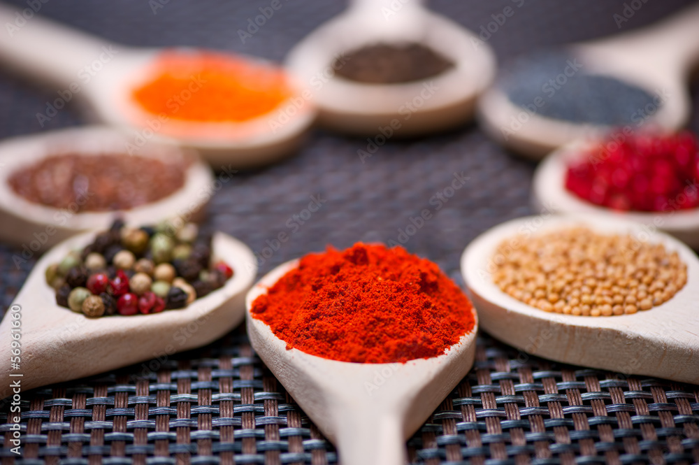 Various kind of spices on wooden spoon - detail of chili powder Various kind of spices on wooden spoon - detail of chili powder