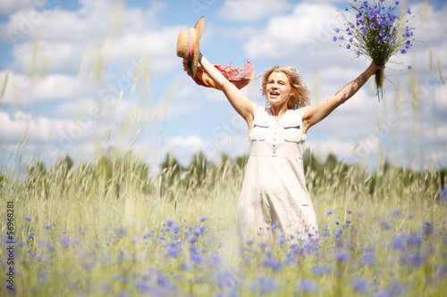 Happy woman in corn field with cornflowers