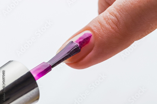 Painting female fingernails with nail polish