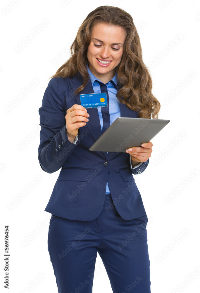 Smiling business woman with credit card using tablet pc Smiling business woman with credit card using tablet pc