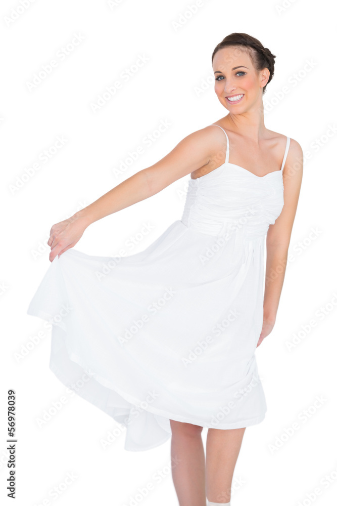 Cheerful beautiful young model in white dress dancing Cheerful beautiful young model in white dress dancing