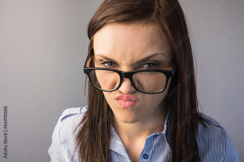 Serious brunette with glasses making faces