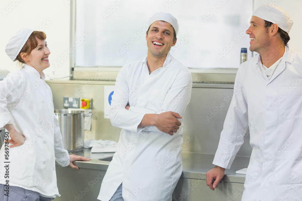Three chatting bakers standing in a bakery Three chatting bakers standing in a bakery