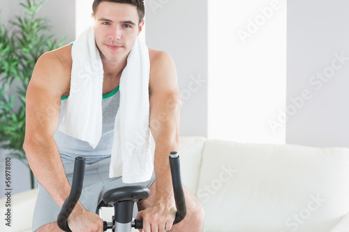 Content handsome man training on exercise bike
