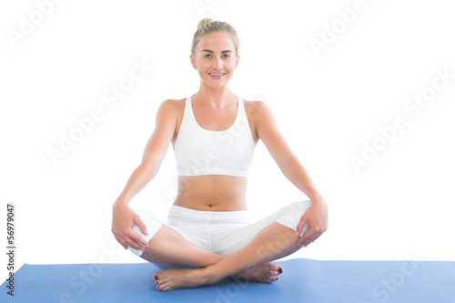 Toned smiling blonde sitting in lotus pose