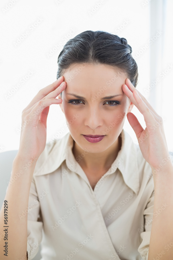 Frowning stylish brunette businesswoman posing looking at camera