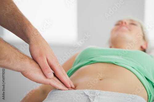 Physiotherapist pressing patients pelvis photo