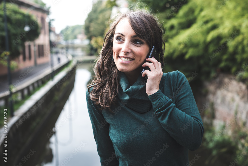 beautiful woman with turtleneck on the phone in the city