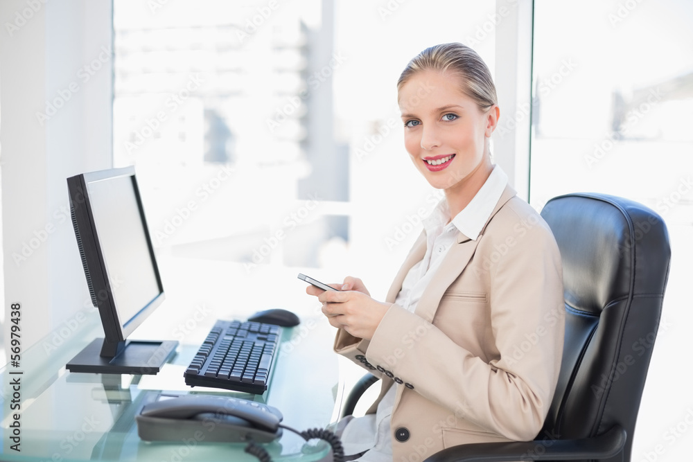 Cheerful blonde businesswoman text messaging Cheerful blonde businesswoman text messaging